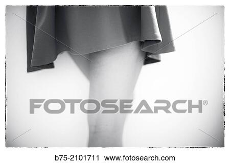 Stock Image - Closeup of legs of a young girl with miniskirt. Fotosearch