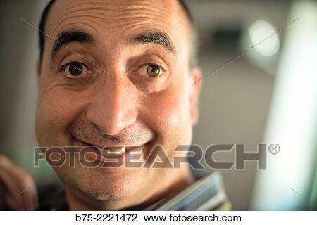 Stock Image - Closeup of the face of a happy middle aged man, with a smile and a surprise look. Fotosearch