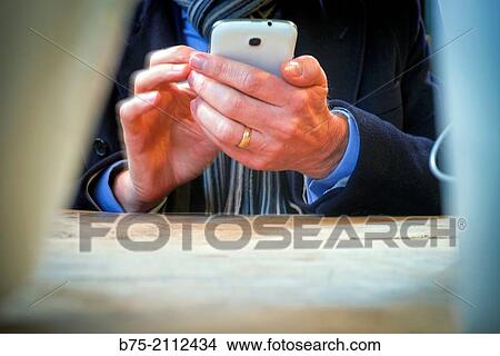 Closeup of the hands of a man unrecognizable manipulating one phone. London, England, UK, Europe. View Large Photo Image Picture - Closeup of the hands of a man unrecognizable manipulating one phone. London, England, UK, Europe.. Fotosearch
