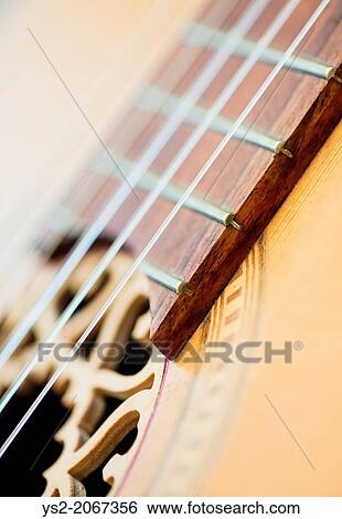 Stock Photograph - Closeup of wooden acoustic guitar strings.. Fotosearch
