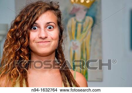 Closeup of young girl with curly hair posing to the camera making faces. View Large Photo Image Picture - Closeup of young girl with curly hair posing to the camera making faces.. Fotosearch