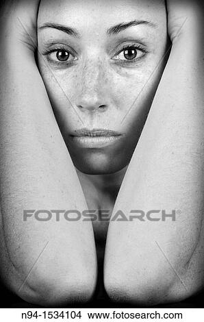 Closeup of young woman, face resting on her arms and looking at the camera. View Large Photo Image Picture - Closeup of young woman, face resting on her arms and looking at the camera.. Fotosearch