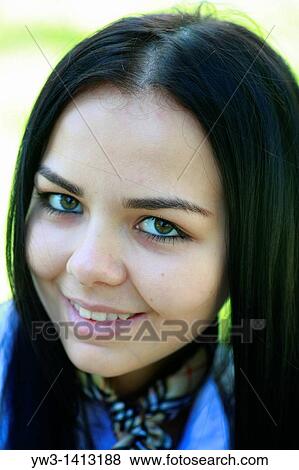 Stock Photo - Closeup portrait of a beautiful 20-25 years happy woman in blur background outdoors. Fotosearch