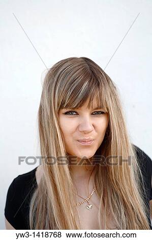 Stock Photo - Closeup portrait of a beautiful 20-25 years woman outdoors with funny face. Fotosearch