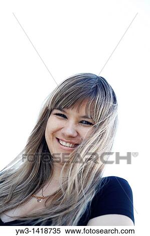 Stock Photography - Closeup portrait of a beautiful 20-25 years happy woman in blur background outdoors. Fotosearch