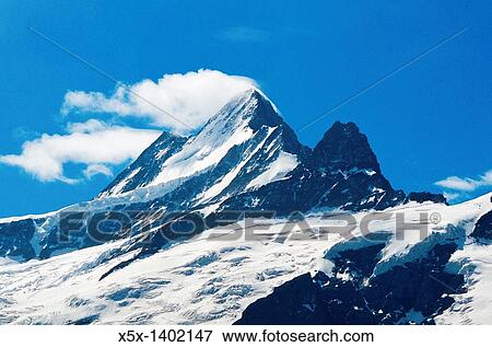 Cloud streaming of the peak of a mountain in the Swiss Alps, Switzerland View Large Photo Image Stock Photo - Cloud streaming of the peak of a mountain in the Swiss Alps, Switzerland. Fotosearch