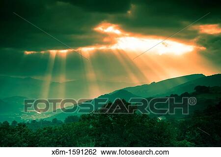 Stock Image - Clouds and sunbeams Baztan valley, Navarre, Spain. Fotosearch