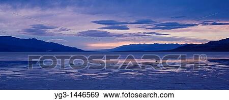 Cloudy winter sunset over temporary lake in flooded Badwater Basin, Death Valley national park, California View Large Photo Image Stock Photo - Cloudy winter sunset over temporary lake in flooded Badwater Basin, Death Valley national park, California. Fotosearch