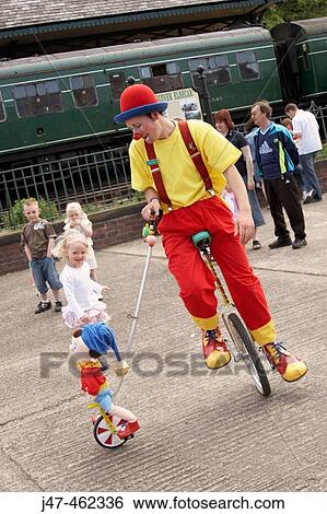 Clown on a bike outside, with a noddy toy and children watching View Large Photo Image Stock Photograph - Clown on a bike outside, with a noddy toy and children watching. Fotosearch