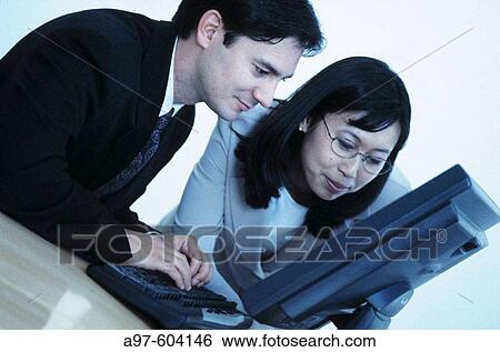Co-workers using lap top computer View Large Photo Image Stock Photograph - Co-workers using lap top computer. Fotosearch