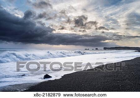 Stock Photo - Coast of the North Atlantic near Vik y Myrdal during winter, view towards the stacks and sea arch at cape Dyrholaey. europe, northern europe, scandinavia, iceland, February.. Fotosearch