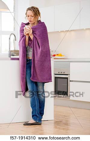 Cold young woman wrapped in a blanket drinking tea View Large Photo Image Stock Image - Cold young woman wrapped in a blanket drinking tea. Fotosearch