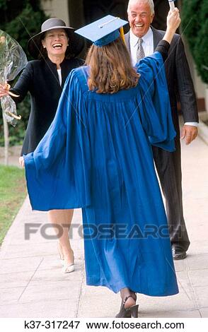 College graduate greeting her parents at graduation ceremony on campus View Large Photo Image Stock Photo - College graduate greeting her parents at graduation ceremony on campus. Fotosearch