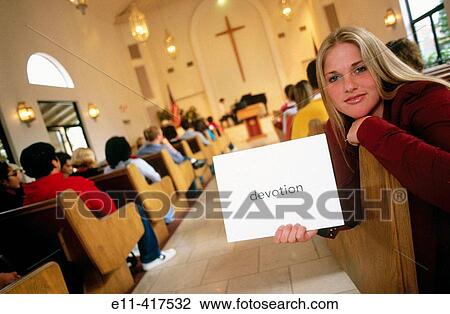 College student holding sign? Devotion? during church service. View Large Photo Image Stock Image - College student holding sign? Devotion? during church service.. Fotosearch