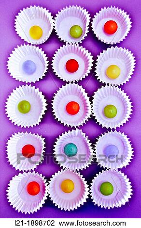 Colored balls in cupcake holders on violet background View Large Photo Image Stock Image - Colored balls in cupcake holders on violet background. Fotosearch
