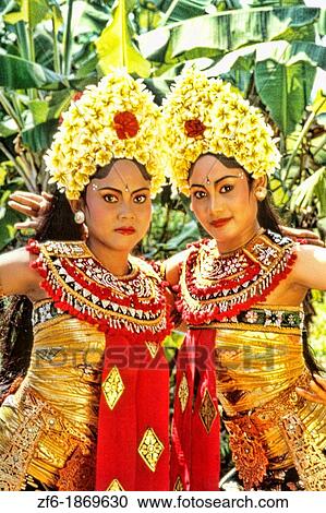 Stock Image - Colorful golden dancers in traditional dress with gestures in Bali Indonesia. Fotosearch