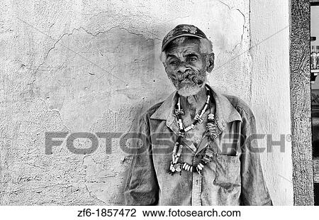Stock Image - Colorful local man on yellow wall in colorful Trinidad Cuba Colonial city. Fotosearch