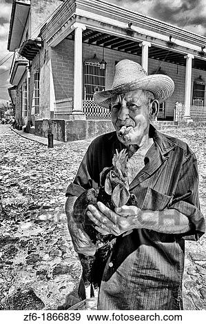 Stock Photo - Colorful Portrait of Man and Rooster in Old Colonial Village Trinidad Cuba. Fotosearch