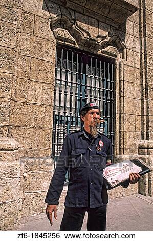 Stock Photograph - Colorful Stone Wall Street Scene Man with Cigar Old Havana Cuba. Fotosearch