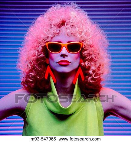 Colorfully-dressed woman with pink hair, green sleeveless dress, orange sunglasses against blue venetian blind backdrop View Large Photo Image Stock Photography - Colorfully-dressed woman with pink hair, green sleeveless dress, orange sunglasses against blue venetian blind backdrop. Fotosearch