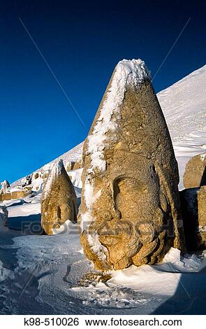 Stock Photograph - Colossal heads of Herakles and Apollo, remains of the tomb-sanctuary of King Antiochus Theos in the West terrace of Nemrut Dag (Mount Nemrut, 2150 m) part of the former Commagene kingdom. Anatolia, Turkey. Fotosearch