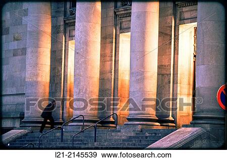 Columns and interior light at dusk, night. View of central post office building designed by Josep Goday Casals and Jaume Torres Grau. Blurred man upstairs. Barcelona, Catalonia, Spain. View Large Photo Image Stock Photo - Columns and interior light at dusk, night. View of central post office building designed by Josep Goday Casals and Jaume Torres Grau. Blurred man upstairs. Barcelona, Catalonia, Spain.. Fotosearch