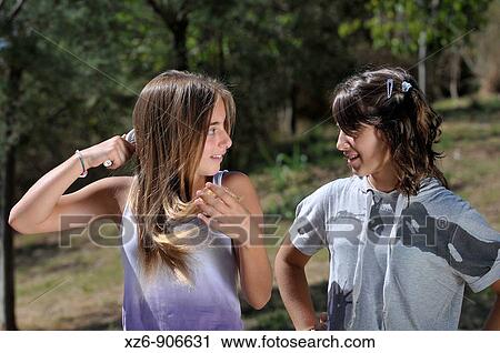 combing girl in the park while talking to a friend View Large Photo Image Stock Image - combing girl in the park while talking to a friend. Fotosearch