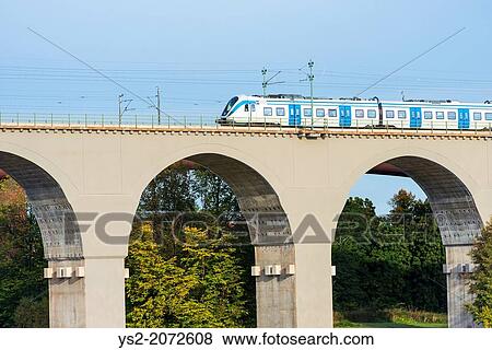 Commuter train passing on a railway bridge. Stockholm, Sweden. View Large Photo Image Stock Photo - Commuter train passing on a railway bridge. Stockholm, Sweden.. Fotosearch