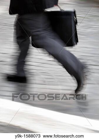 Stock Image - Commuter with briefcase in city town. Fotosearch
