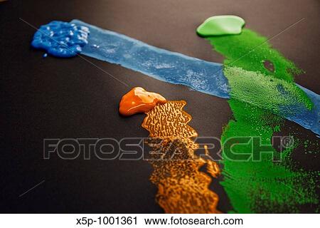 Stock Image - Composici? n de tres colores de pintura: naranja, azul y verde / Composition of three paint colors: orange, blue and green. Fotosearch