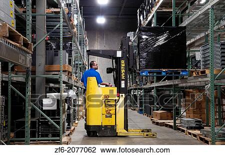 Stock Image - computer technology IT company shipping inventory man with forklift moving computer inventory.. Fotosearch