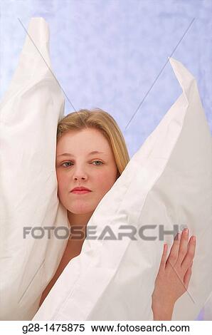Concept: young woman burrying herself in her pillows because of overstress or fear, depression, or desire to cut herself from the world around View Large Photo Image Stock Photography - Concept: young woman burrying herself in her pillows because of overstress or fear, depression, or desire to cut herself from the world around. Fotosearch