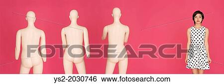 Conceptual portrait of young serious multiracial woman standing alone, left out from a group of mannequins. 1015 View Large Photo Image Stock Photograph - Conceptual portrait of young serious multiracial woman standing alone, left out from a group of mannequins. 1015. Fotosearch