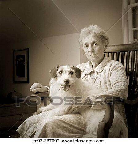 Concerne, worried looking elderly woman sitting on rocker in attic room (apparent from rooms ceiling line) with small dog on lap. Both looking at camera. View Large Photo Image Stock Photo - Concerne, worried looking elderly woman sitting on rocker in attic room (apparent from rooms ceiling line) with small dog on lap. Both looking at camera.. Fotosearch