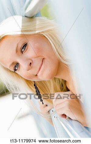 Concerned young woman portrait, looking through metal fence View Large Photo Image Picture - Concerned young woman portrait, looking through metal fence. Fotosearch