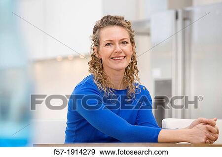 Stock Photo - Confident young businesswoman sitting at a table. Fotosearch