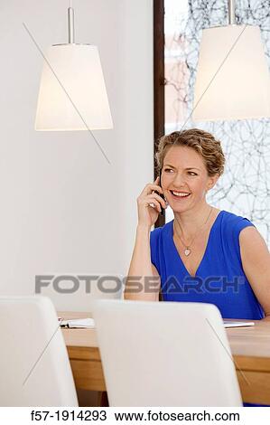 Confident young businesswoman talking on her smartphone View Large Photo Image Stock Image - Confident young businesswoman talking on her smartphone. Fotosearch