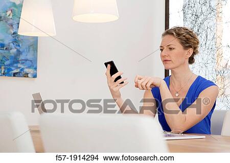 Confident young businesswoman working on her smartphone View Large Photo Image Picture - Confident young businesswoman working on her smartphone. Fotosearch