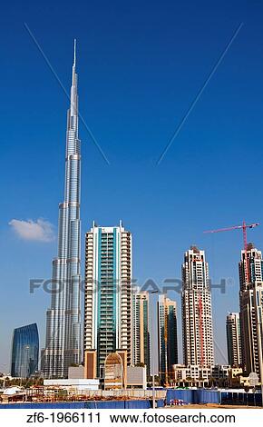 Stock Image - Construction and new skyline of amazing Dubai UAE with the world's tallest building Burj Khalifa at 2722 feet and 162 stories in thriving new United Arab Emirates in Middle East in Gulf States.. Fotosearch