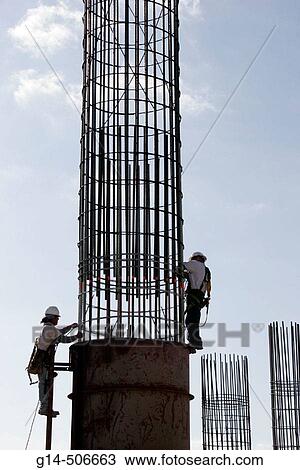 Stock Image - Construction, concrete reinforcing bars, men, hard hats, work, job. South Pointe, Miami Beach, Florida. Fotosearch