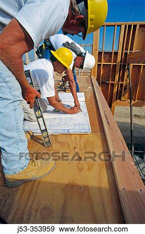 Stock Photo - Construction foreman giving instructions to carpenters on jobsite for school construction, Antelope California USA. Fotosearch