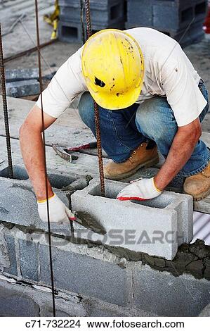 Construction mason laying cement blocks View Large Photo Image Picture - Construction mason laying cement blocks. Fotosearch
