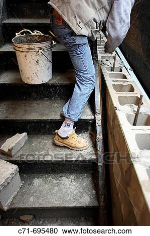 Construction mason worker laying cement block View Large Photo Image Stock Image - Construction mason worker laying cement block. Fotosearch