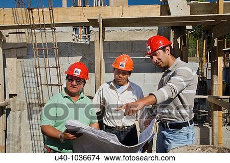 Picture - Construction site, architects with blue prints. Fotosearch