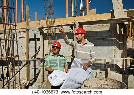 Stock Image - Construction site, architects with blue prints. Fotosearch