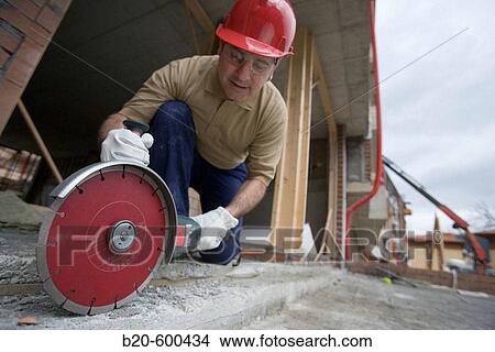 Construction worker cutting concrete block with electroportable machine with diamond disc. Building houses. View Large Photo Image Picture - Construction worker cutting concrete block with electroportable machine with diamond disc. Building houses.. Fotosearch