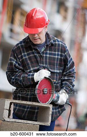 Construction worker cutting concrete block with electroportable machine with diamond disc. Building houses. View Large Photo Image Stock Image - Construction worker cutting concrete block with electroportable machine with diamond disc. Building houses.. Fotosearch