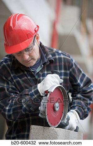 Construction worker cutting concrete block with electroportable machine with diamond disc. Building houses. View Large Photo Image Stock Image - Construction worker cutting concrete block with electroportable machine with diamond disc. Building houses.. Fotosearch