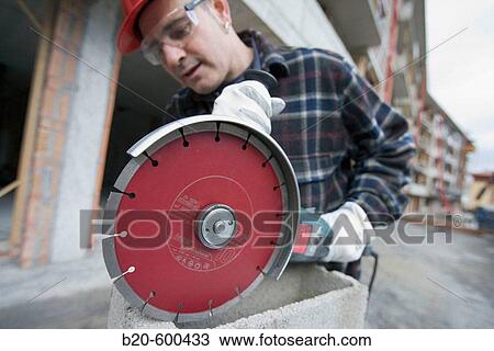 Construction worker cutting concrete block with electroportable machine with diamond disc. Building houses. View Large Photo Image Stock Image - Construction worker cutting concrete block with electroportable machine with diamond disc. Building houses.. Fotosearch