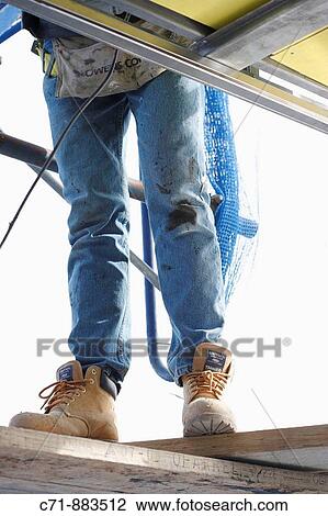 Construction worker from below standing on wood planking View Large Photo Image Stock Image - Construction worker from below standing on wood planking. Fotosearch